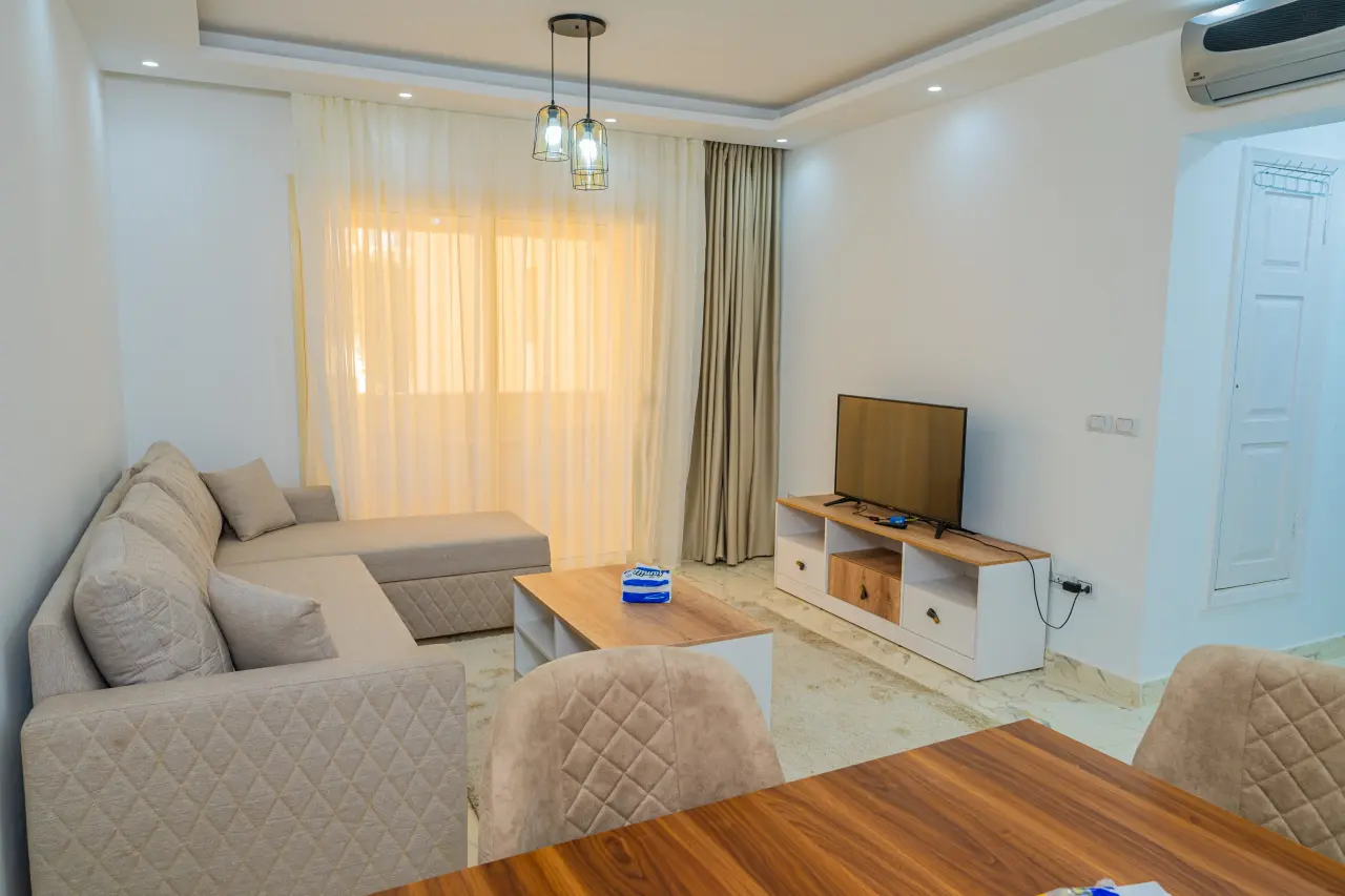 Svetlá obývacia izba so sedačkou a TV v apartmáne v Egypte